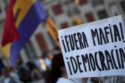 Detalle de una pancarta durante la manifestación que varios centenares de personas han llevado a cabo hoy en la capital, bajo el lema "Fuera mafia, hola democracia", convocados por el movimiento 15M, para denunciar que políticos y banqueros, a los que consideran "la élite corrupta", son responsables de la actual situación de crisis.