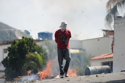 Um manifestante anda perto de uma barricada durante confrontos com a polícia em Cotiza.