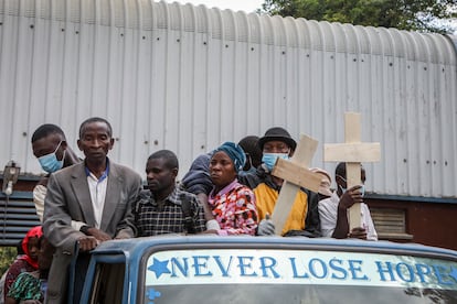 Relatives ride in the back of a truck with the coffins of villagers who were killed by suspected rebels as they retreated from Saturday's attack on the Lhubiriha Secondary School, outside the mortuary of the hospital in Bwera, Uganda Sunday, June 18, 2023.