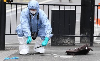 Un policía recoge los cuchillos que se le han requisado al detenido en Londres.