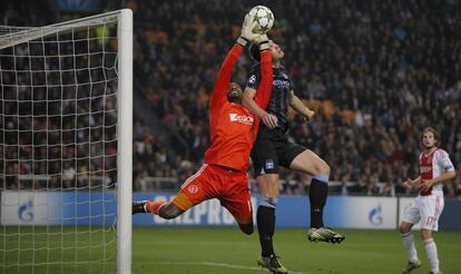 El portero del Ajax, Vermeer, alcanza el balón ante Dzeko.