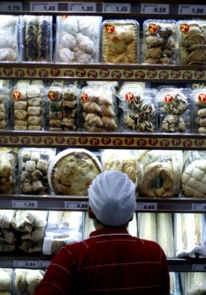 Un empleado ante un lineal con productos de boller&iacute;a en una tienda de Madrid.