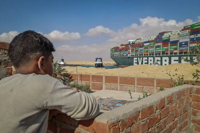 Uma criança observa os trabalhos de resgate no canal de Suez.