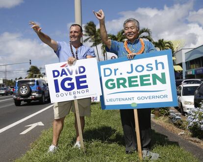 El senador demócrata de Hawaii Josh Green, a la izquierda, y el gobernador de Hawaii David Ige saludan a los conductores, el 6 de noviembre de 2018 en Honolulu.