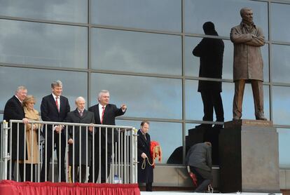 En esta imagen tomada el el 23 de noviembre de 2012 Alex Ferguson (a la izquierda) asiste a la presentación de una estatua en su honor, junto a su esposa Catherine, el presidente del Manchester United David Gill, el escultor Philip Jackson y el presentador de la televisión británica Eamonn Holmes.