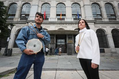 Adrián Peño y Celia Berlinches, dos estudiantes de percusión muestran sus baquetas y una pandereta este viernes en la puerta del Real Conservatorio Superior de Música de Madrid.