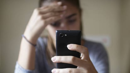Una joven consulta su móvil.