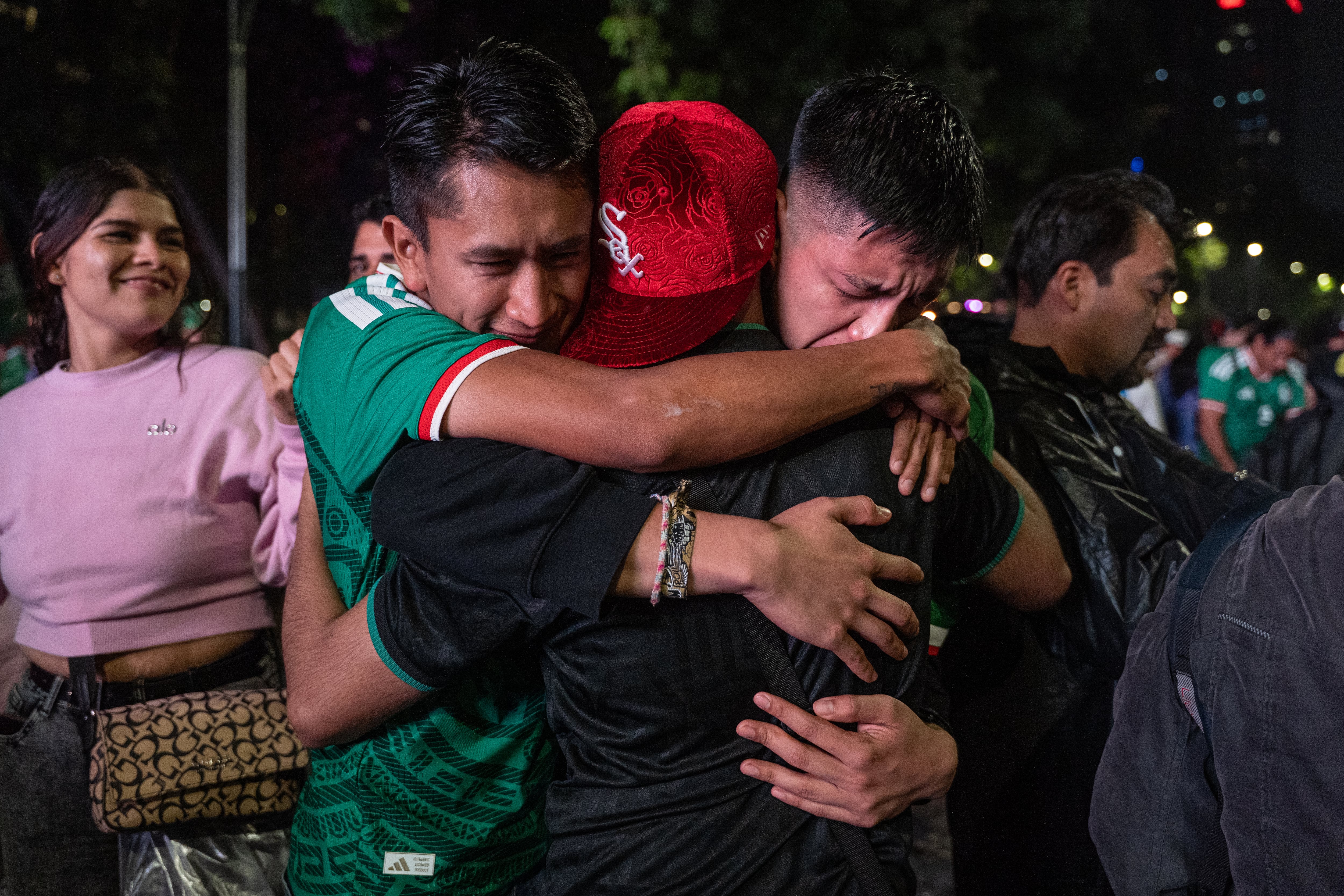 Aficionados se abrazan después del partido México - Inglaterra.  