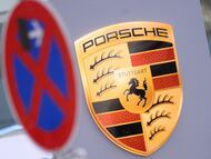 Una señal de no aparcar junto al logo de la marca de coches Porsche, en Colonia, Alemania.