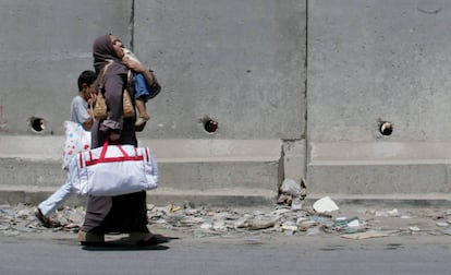 Una palestina y sus hijos caminan por la localidad de Aram.