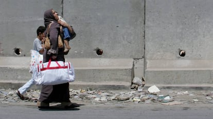 Una palestina y sus hijos caminan por la localidad de Aram.