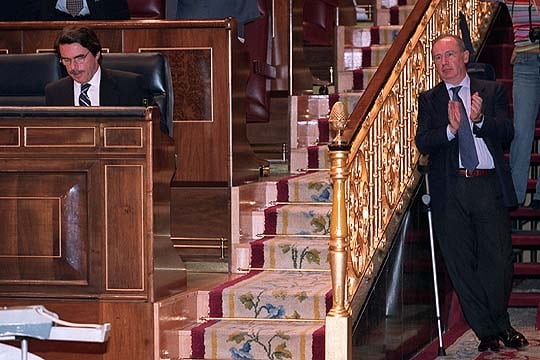 El presidente del Gobierno José María Aznar permanece en su escaño, mientras el vicepresidente segundo Rodrigo Rato aplaude, durante una sesión en el Congreso en 2003.