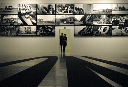 Las fotografías colocadas en la pared del Artium de Vitoria muestran los diferentes lugares por los que ha ido pasando la escultura del No, global tour, de Santiago Sierra.