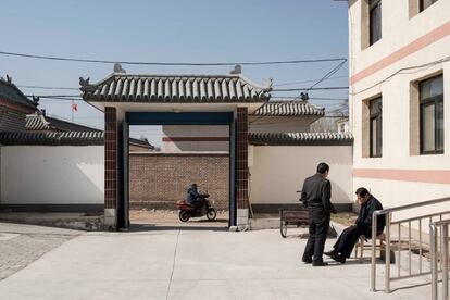 Pan Xin, diagnosticada con autismo, regresa a través del mercado entre residentes del pueblo después de hacer las compras para la Unidad Abierta Residencial de Vila Rosa para las personas con condiciones de salud mental en el distrito de Yinqing, Beijing, China.