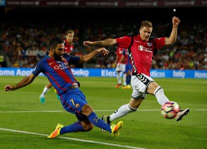 El centrocampista turco del FC Barcelona Arda Turan intenta no perder el balón frente al centrocampista del Alavés Marcos Llorente.