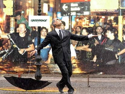 Un activista de Greenpeace disfrazado de George Bush representa <i>Cantando bajo la lluvia</i> junto a la cumbre.