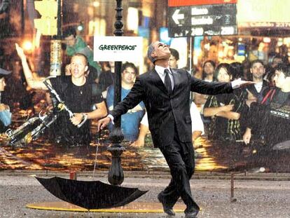 Un activista de Greenpeace disfrazado de George Bush representa <i>Cantando bajo la lluvia</i> junto a la cumbre.