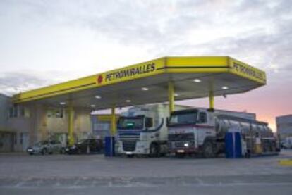 Camiones y vehículos repostando en una gasolinera.