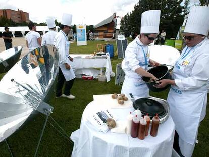 Alumnos de la Escuela de Hostelería de Madrid preparan comidas en los hornos y cocinas solares del puesto de Movimiento Clima.