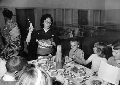 La profesora Michiko Fujii, vestida con kimono y obi, muestra a sus alumnos cómo comer los platos orientales en la cafetería del colegio en Denver (Estados Unidos), en 1969. |