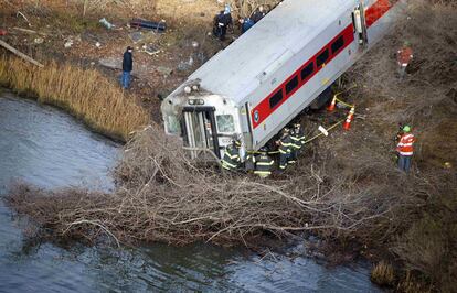 Los trabajadores de emergencia examinan el sitio de un descarrilamiento de tren Metro-North en el barrio del Bronx de Nueva York