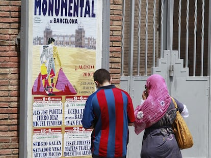 Una pareja contempla ayer el cartel anunciador de la temporada en la Monumental de Barcelona, donde este domingo habrá corrida.