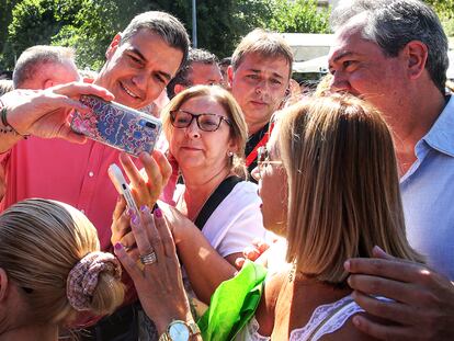 El secretario general del PSOE, Pedro Sánchez (centro), se fotografía con simpatizantes en en el barrio de Pino Montano de Sevilla. A la derecha, el secretario general del PSOE de Andalucía, Juan Espada.