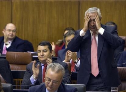 Javier Arenas se cubre ayer la cara con sus manos durante el debate en el Parlamento con José Antonio Griñán.