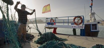 Un pescador prepara su barco para salir a faenar en el puerto de La Atunara, en La Línea.