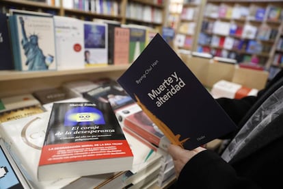 Un hombre toma un libro de filosofía en la la librería Antonio Machado de Madrid.