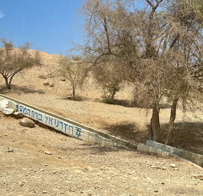 La inscripción en hebreo "volvimos a los pozos de agua" y la estrella de David, pintadas en una canalización de agua en la aldea palestina de Ras ‘Ein al-’Auja, en agosto de 2025.