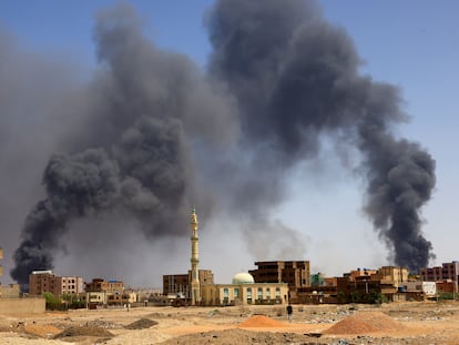 A man walks while smoke rises above buildings after aerial bombardment, during clashes between the paramilitary Rapid Support Forces and the army in Khartoum North, Sudan, May 1, 2023.