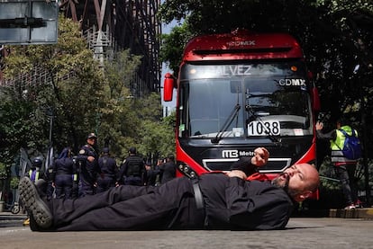 Un manifestante se acuesta sobre el carril confinado del Metrobús en avenida Insurgentes, este martes en Ciudad de México.