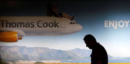 Una persona pasa frente a un cartel de Thomas Cook.