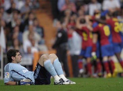 Casillas se lamenta en el césped del Bernabéu mientras los jugadores del Barça, al fondo, celebran su sexto gol.