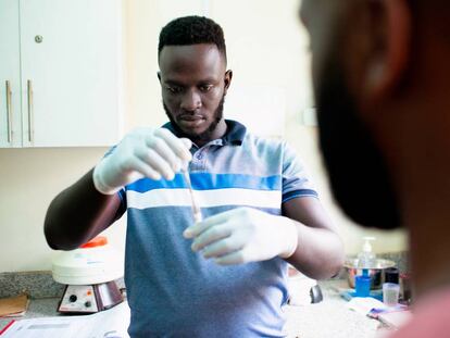 Brian Gitta, uno de los laureados de los Premios Rolex a la iniciativa 2019, realiza un análisis de malaria. (Foto: ©Rolex/ Joan Bardeletti).