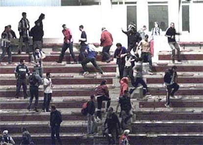 La policía carga ayer en una de las gradas del estadio de San Lázaro.