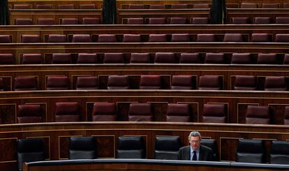 El ministro de Justicia, Alberto Ruiz-Gallardón, trabaja en su escaño de un hemiciclo vacío, en el Congreso de los Diputados, el 14 de marzo de 2013.