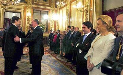 Tras el acto solemne, el Rey ha saludado en el Salón de los Pasos Perdidos a las figuras políticas y sociales que se han dado cita en el Congreso. En la imagen, el monarca da la mano al secretario general del PSOE, José Luis Rodríguez Zapatero, ante la sonrisa del presidente del Gobierno, José María Aznar.