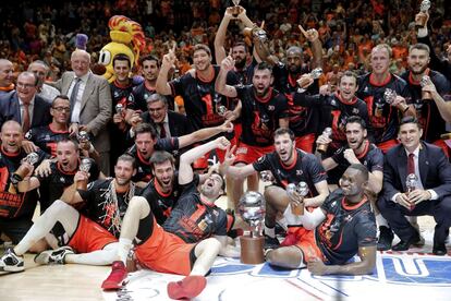 Los jugadores del Valencia Basket celebran con la copa el título de campeones de la Liga ACB tras imponerse en el cuarto partido al Real Madrid esta noche en el pabellón de la Fuente de San Luis de Valencia.