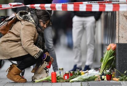 Una mujer coloca una vela cerca de la escena del bar donde varias personas fueron asesinadas la noche del miércoles en Hanau (Alemania).