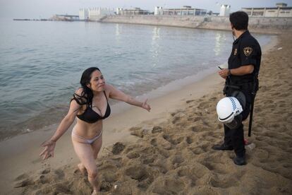 Una chica sale del agua después de las órdenes de un agente.