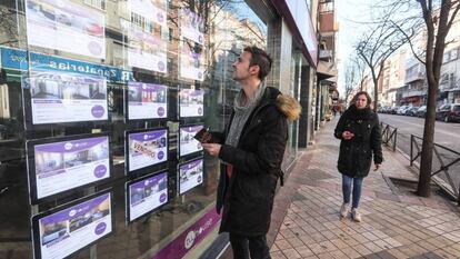 Un joven observa la oferta de pisos de una inmobiliaria en Madrid.