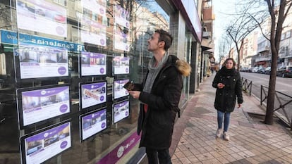 Un joven observa la oferta de pisos de una inmobiliaria en Madrid.