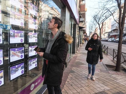 Un joven observa la oferta de pisos de una inmobiliaria en Madrid.