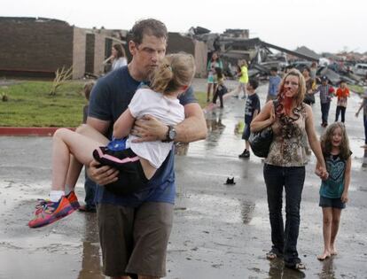 Dos profesores ayudan a varios de sus alumnos después de azote del tornado.