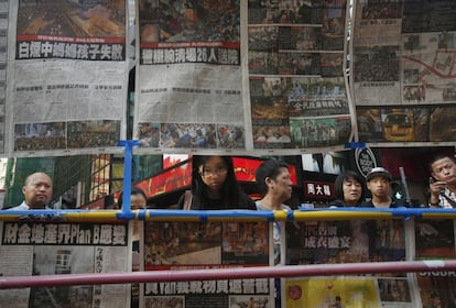 Unos ciudadanos leen los titulares de prensa sobre los enfrentamientos entre la policía y los manifestantes participantes en la protesta pro democracia, en Hong-Kong, China.