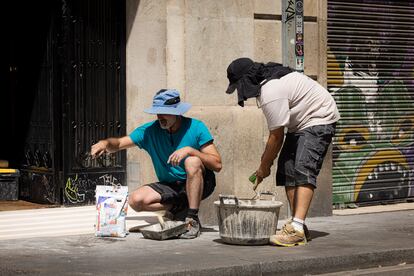 Trabajadores en el barrio del Raval, este lunes en Barcelona.