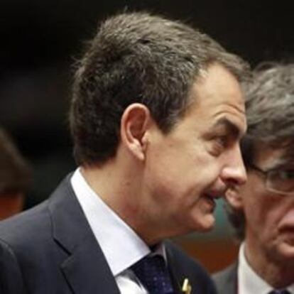 El presidente del Gobierno español, José Luis Rodríguez Zapatero (i), conversa con el presidente francés, Nicolas Sarkozy (d), al inicio de la cumbre de líderes europeos.