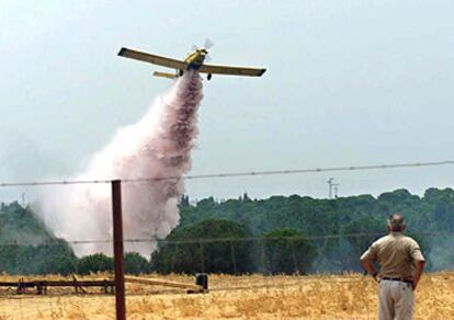Una avioneta descarga agua ayer sobre el incendio de Valverde del Camino, el más grande registrado este año en Huelva.